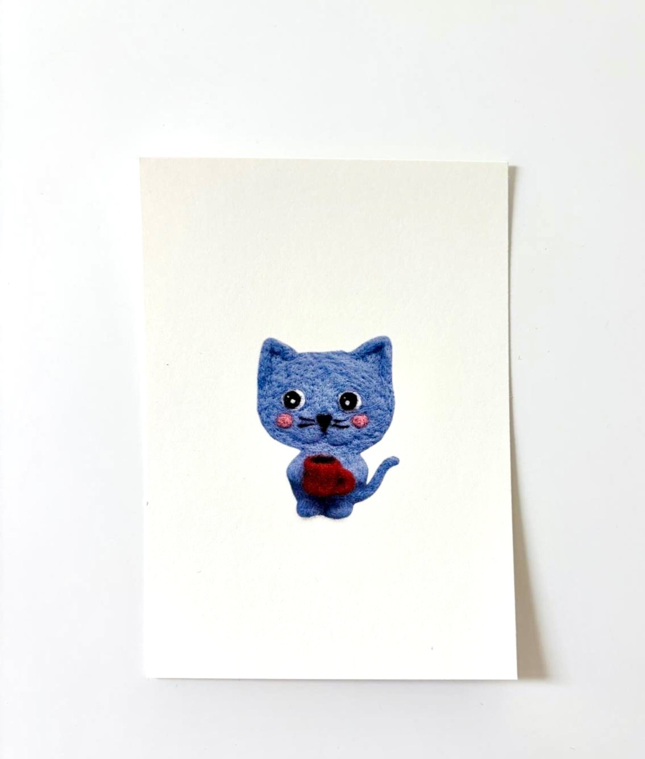 Wenskaart Blauw Katje met Koffiebeker – Illustratie van een Wollen Katje