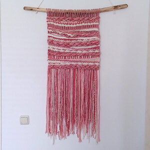 Zalmkleurig roze wandkleed aan een tak