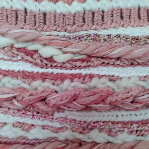 Zalmkleurig roze wandkleed aan een tak