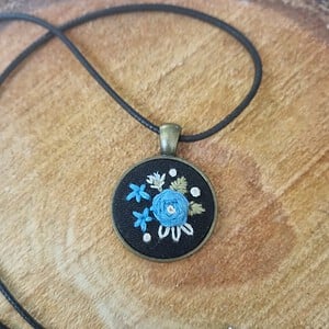 Unieke geborduurde hanger met blauwe roos