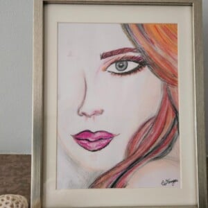Portret in pastel van jonge vrouw met oranje roze haar, pastelschilderij ingelijst