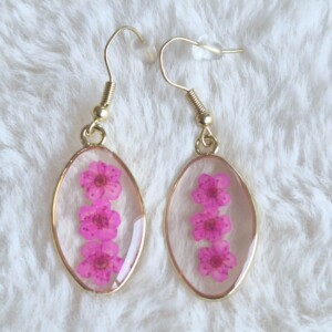 Roze gedroogde bloem gouden ovale resin oorbellen