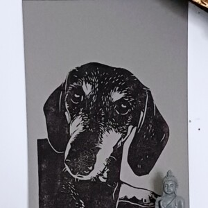 Linoprint ‘Takkie de Teckel’ – gesigneerde A5 hondenkaart in zwart op grijs papier
