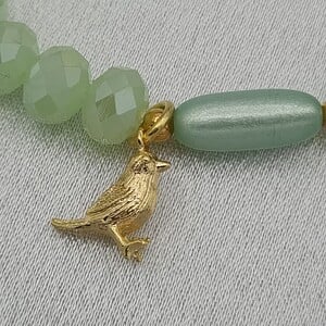 Handgemaakte armband met vergulde bedel