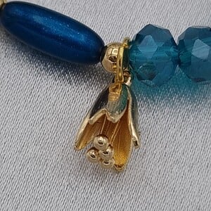 Handgemaakte armband met vergulde bedel - petrol