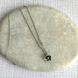 Verzilverde ketting met bloemetje en peridoot kraaltje