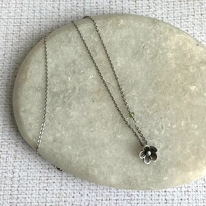 Verzilverde ketting met bloemetje en peridoot kraaltje