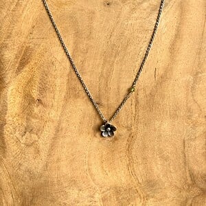 Verzilverde ketting met bloemetje en peridoot kraaltje