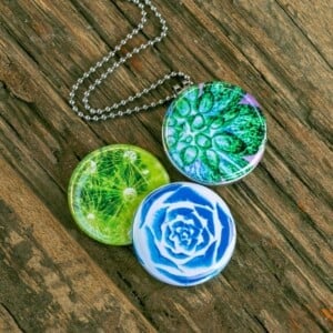 Fotomedaillon ketting met drie verschillende verwisselbare voorkanten met close up foto`s van buitenaards aandoende bloemen,nachtbloemen.Magisch magnetisch medaillon. Voor het dicht bij je dragen van je favoriete foto.