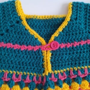 Gehaakt baby vestje | Petrol, roze en geel met roze franjes