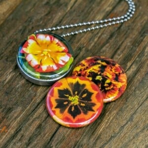 Fotomedaillon ketting/medaillon ketting met close up bloemen  foto`s in rood geel en oranje. Voor het dicht bij je dragen van je favoriete foto.