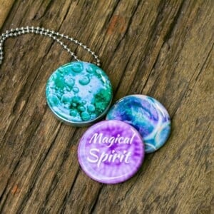 Roestvrij stalen fotomedaillon ketting met drie verschillende verwisselbare voorkanten met close up foto`s in mint groen,lila en paarse tinten. Rvs/roesvrij stalen fotomedaillon. Voor het dicht bij je dragen van je favoriete foto.