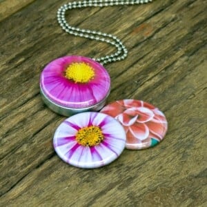 Roestvrij stalen fotomedaillon ketting met drie verschillende verwisselbare voorkanten met close up foto`s van roze,witte en zalm kleurige bloemen. Rvs/roesvrij stalen fotomedaillon. Voor het dicht bij je dragen van je favoriete foto.