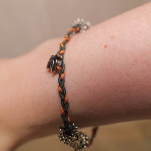 Gevlochten armband donkergroen en koperbruin met metalen kralen