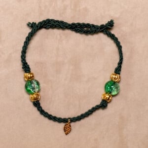 Gevlochten donkergroene armband met gekraakte kralen en goudkleurig blaadje
