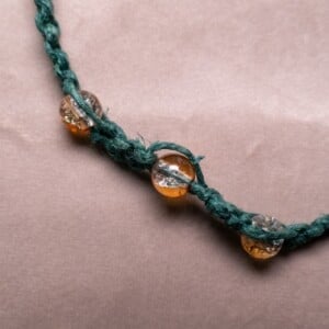 Groene hennep armband met oranje crackle glaskralen