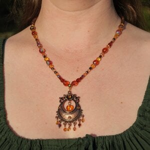 Ketting met antiek koperkleurig ornament, hart en amberkleurige facetkralen