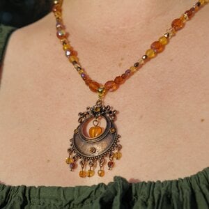 Ketting met antiek koperkleurig ornament, hart en amberkleurige facetkralen