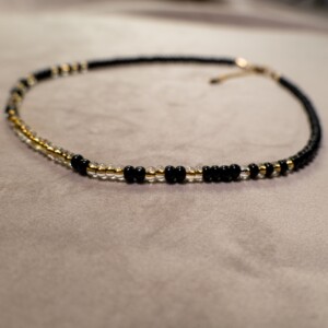 Ketting met zwarte rocailles en transparante kralen met gele kern