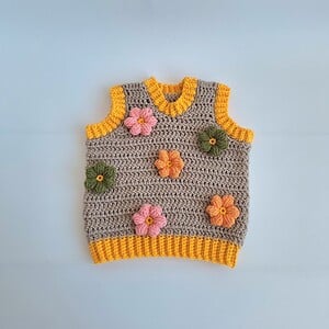 Gehaakt baby vestje | Beige en geel met lichtroze, groene en oranje bloemen