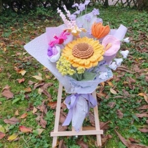 Handgemaakt haakboeket met grote zonnebloem en kleurrijke veldbloemen