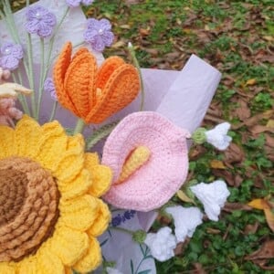 Handgemaakt haakboeket met grote zonnebloem en kleurrijke veldbloemen