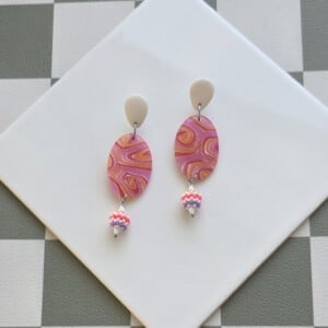 Handgemaakte oranje, roodroze, lila, witte oorbellen van polymeerklei en kralen | Swirl