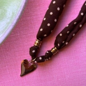 Stof ketting van bruine stof met witte stippen