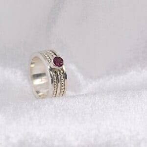 Vier zilveren ringen samengevoegd tot één – met roze toermalijn