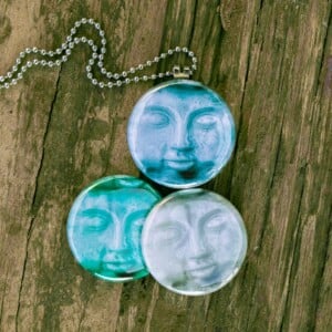 Buddha ketting,budha medaillon,budha gezicht,buddha face,Fotomedaillon ketting met drie verschillende verwisselbare voorkanten met foto`s van budha,Blauw grijze buddha gezichten. Voor het dicht bij je dragen van je favoriete foto.
