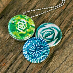 Roestvrij stalen foto medaillon ketting, met afbeeldingen in groen blauwe tinten. Rvs/roesvrij stalen fotomedaillon. Voor het dicht bij je dragen van je favoriete foto.