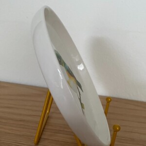 Vogel op een rond bordje met standaard.