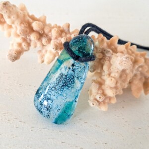 Handgemaakte hanger van versmolten glas in aqua turquoise blauw, groen en zwart, inclusief verstelbare ketting.