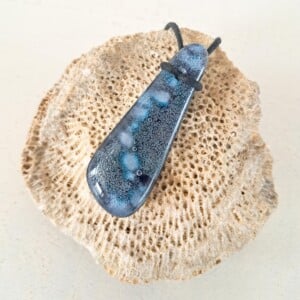 Handgemaakte hanger van versmolten glas in blauw.paars. wit en zwart, inclusief verstelbare ketting.