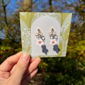 Micro gehaakte kersenbloesem oorbellen met strikje – zacht roze & goud