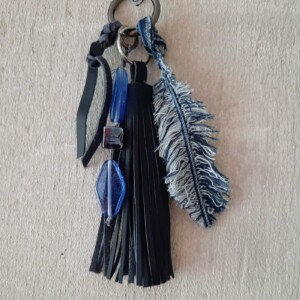 Sleutelhanger handgemaakt met leren kwast, kralen en denim veer. Ook te gebruiken als Bagcharm, tassenhanger