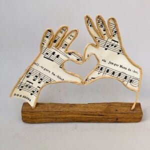 Handen met liefde, draadfiguur, draadwerk van ijzerdraad en papier op steigerhout