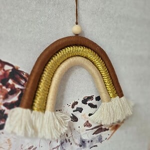 Handgemaakte regenboog hanger (15 × 11 cm) in warme aardetinten. Uniek, lichtgewicht en perfect voor elke kamer