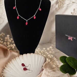 Set van oorbellen en halsketting met rode glazen druppels
