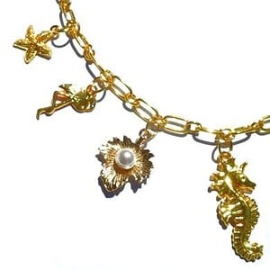 Goudkleurige halsketting met goudkleurige metalen bedels. Handgemaakte ketting met goudkleurige schakels, sluiting en bedel strand zee zomer