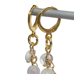 Goudkleurige oorringen met handgemaakte hanger. Bedel met beschermend oog, bedel met halfedelsteen, Ibiza creolen, Per Elle sieraden, oorbel