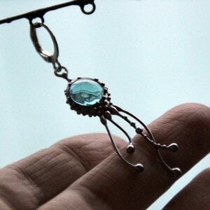 Handgemaakte enkele octopusoorbel met blauw glas en zilverkleurig koper