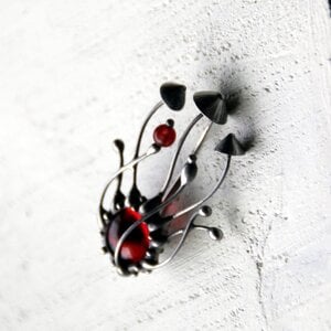Handgemaakte paddenstoelenbroche met rood glas en zilverkleurig koper