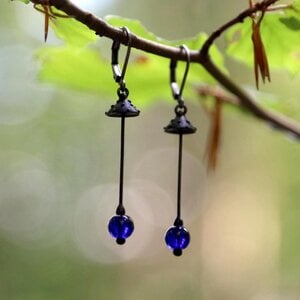 Handgemaakte vliegenzwamoorbellen met blauw glas en zwart gepatineerd koper