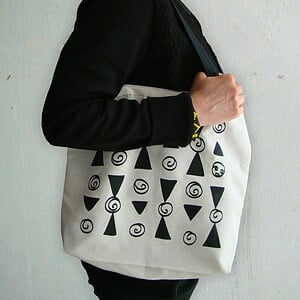 Tote bag met geometrisch patroon van zwarte driehoeken en spiralen