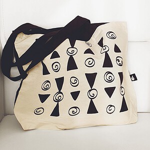 Tote bag met geometrisch patroon van zwarte driehoeken en spiralen