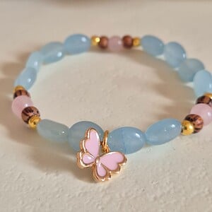 Vrolijke roze/gouden vlinder armband