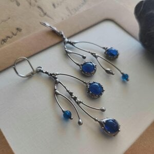 Asymmetrische handgemaakte takoorringen met blauw glas en zilverkleurig koper