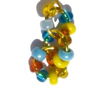 Goudkleurige oorbellen met ringen en glaskralen van turquoise, oranje en geel. Goudkleurige oorhaken met handgemaakte unieke hangers, Per Elle sieraden