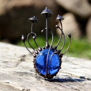 Handgemaakte paddenstoelenbroche met blauw glas en zwart gepatineerd koper